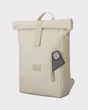 Cremefarbener Rolltop Rucksack 'Adam Medium' aus Canvas mit seitlicher Reißverschlusstasche, in der ein schwarzes Smartphone steckt