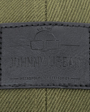 Schwarzes Lederetikett mit Johnny Urban Logo und Text auf grün-schwarzem Canvas-Material.