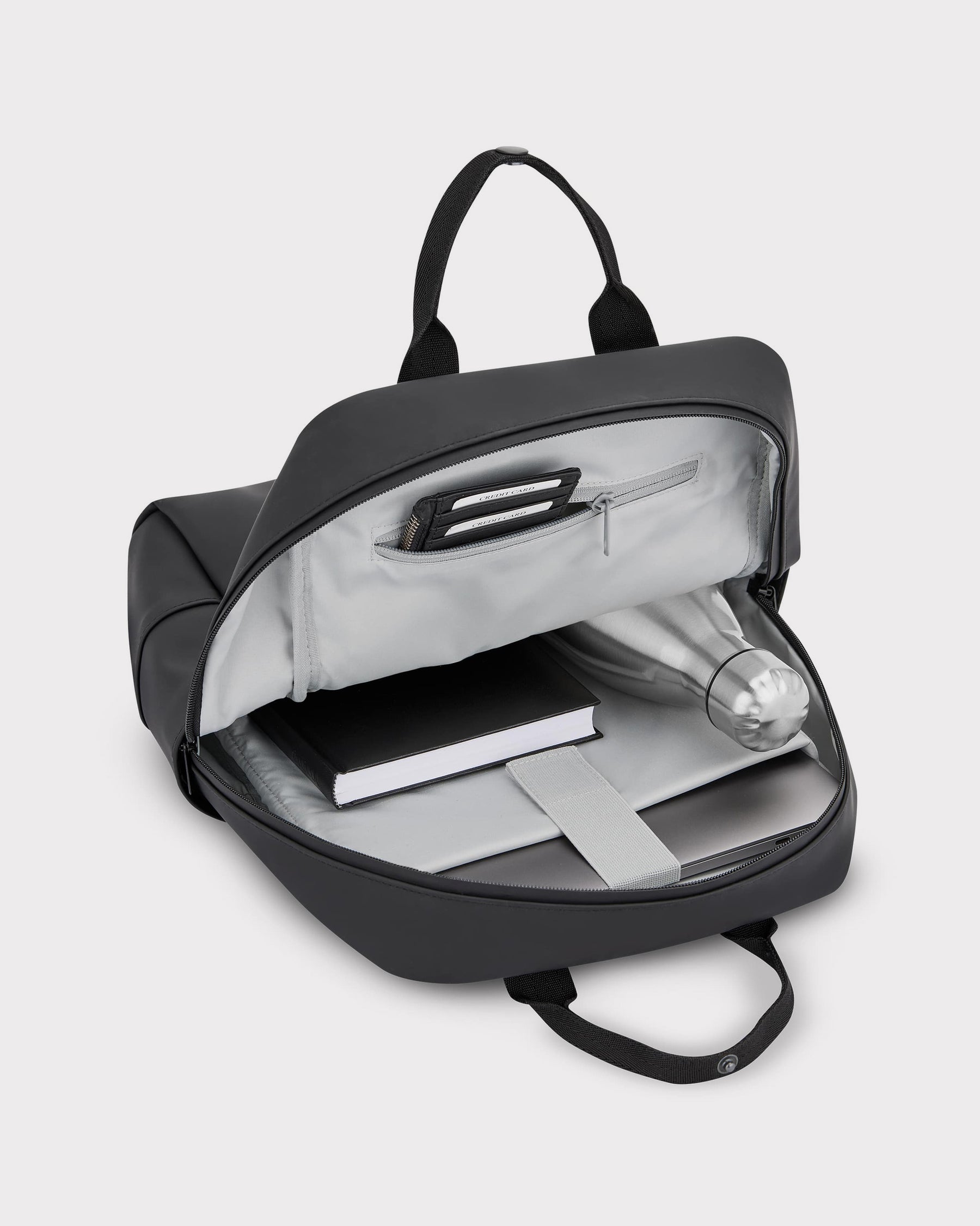 Schwarzer Damenrucksack 'Hailey' geöffnet mit Innentaschen, Wasserflasche, Buch und Laptopfach