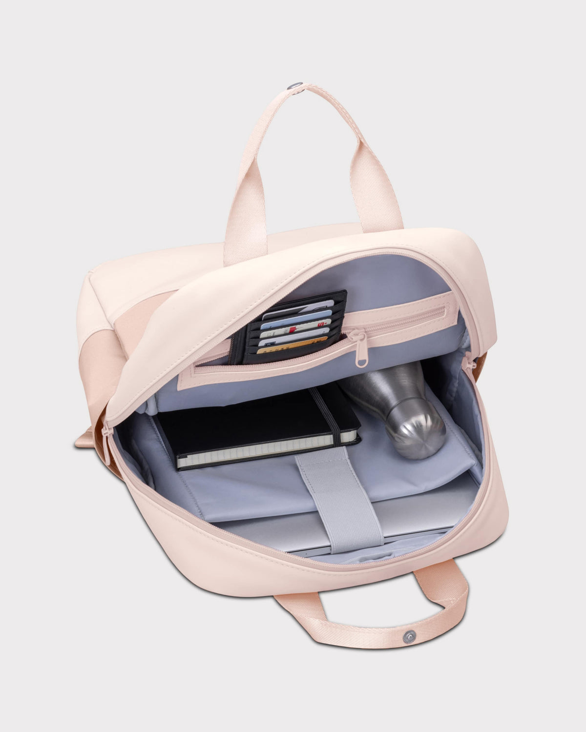 Rucksack 'Jona Medium' in Rosa, geöffnet mit Fächern für Karten, Notizbuch, Trinkflasche und Laptopfach
