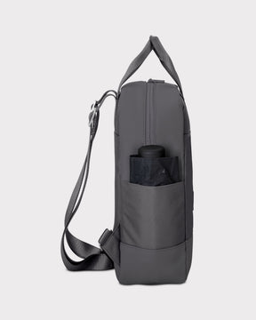 Dunkelgrauer Damenrucksack "Jona Small" mit seitlicher Außentasche, in der ein kompakter Regenschirm steckt