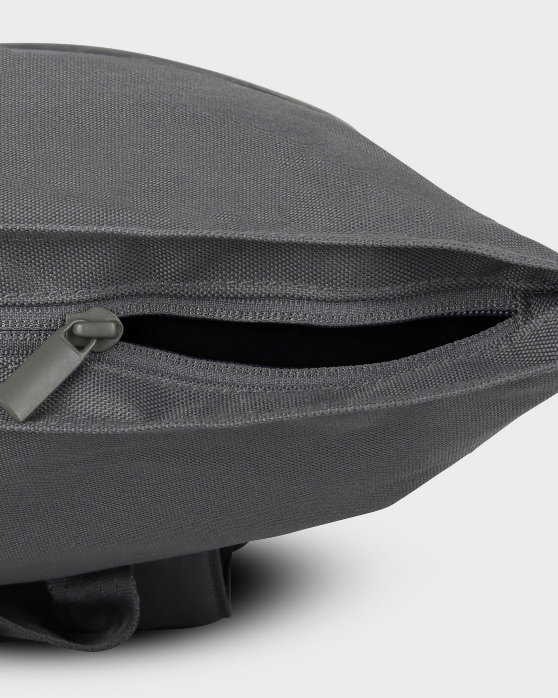 Großes seitliches Reißverschlussfach des Rolltop Rucksackes 'Robin Large' in dunkelgrauem robustem Material