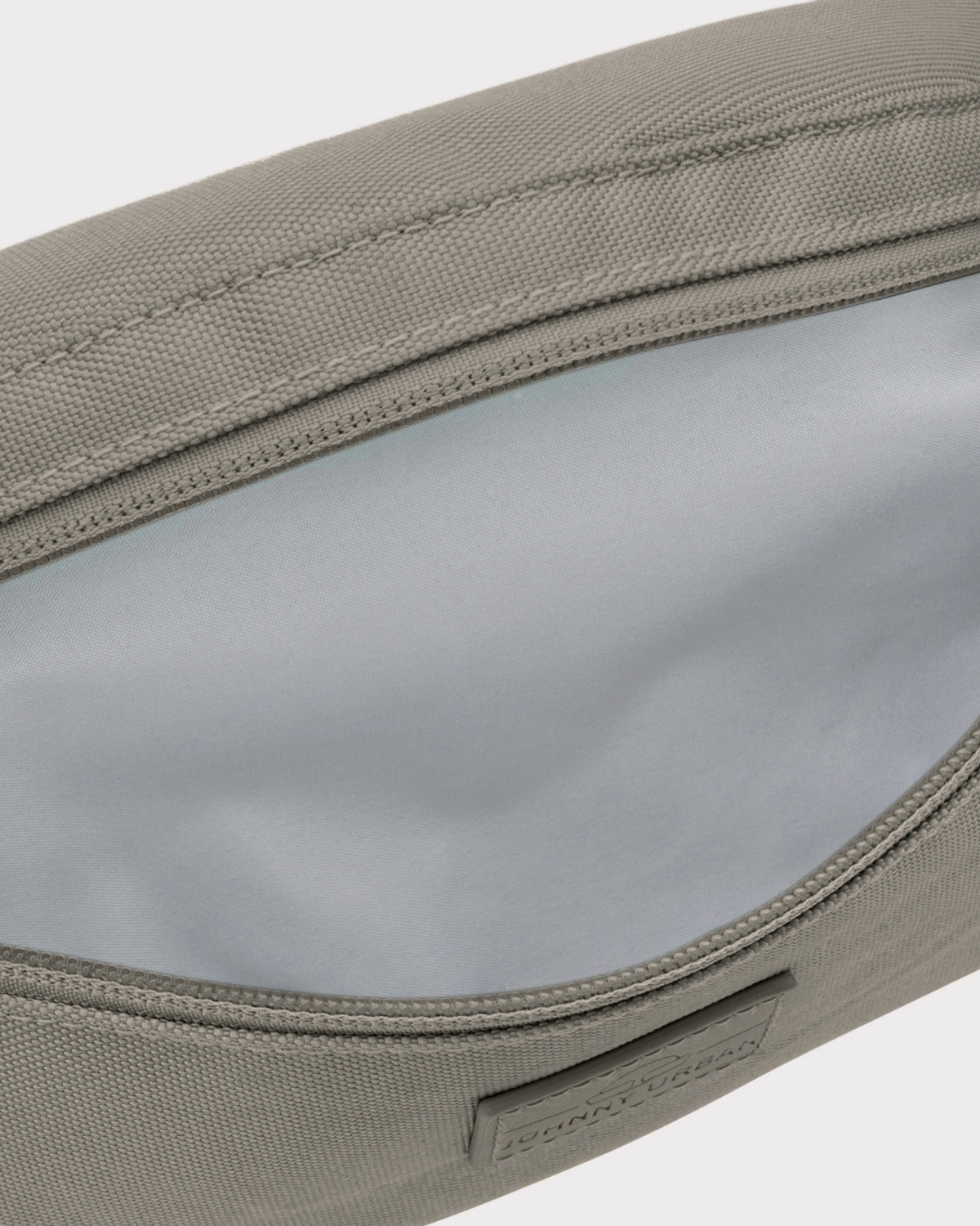 Nachhaltige Bauchtasche 'Erik Small' in desert grey mit geöffnetem Hauptfach und grauem Innenfutter