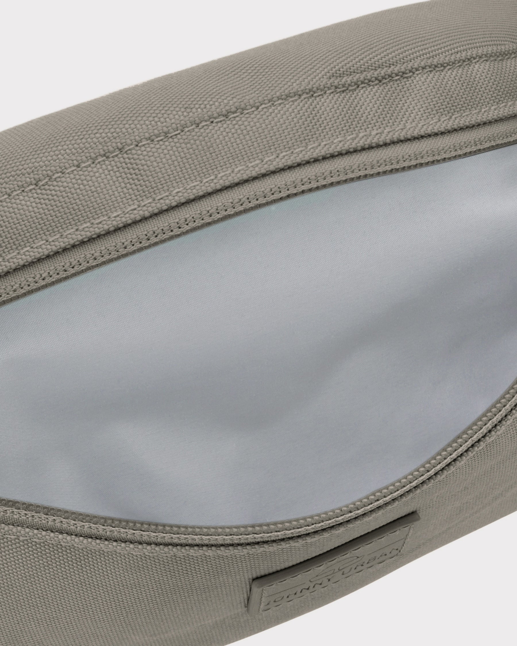 Nachhaltige Bauchtasche 'Erik Small' in desert grey mit geöffnetem Hauptfach und grauem Innenfutter