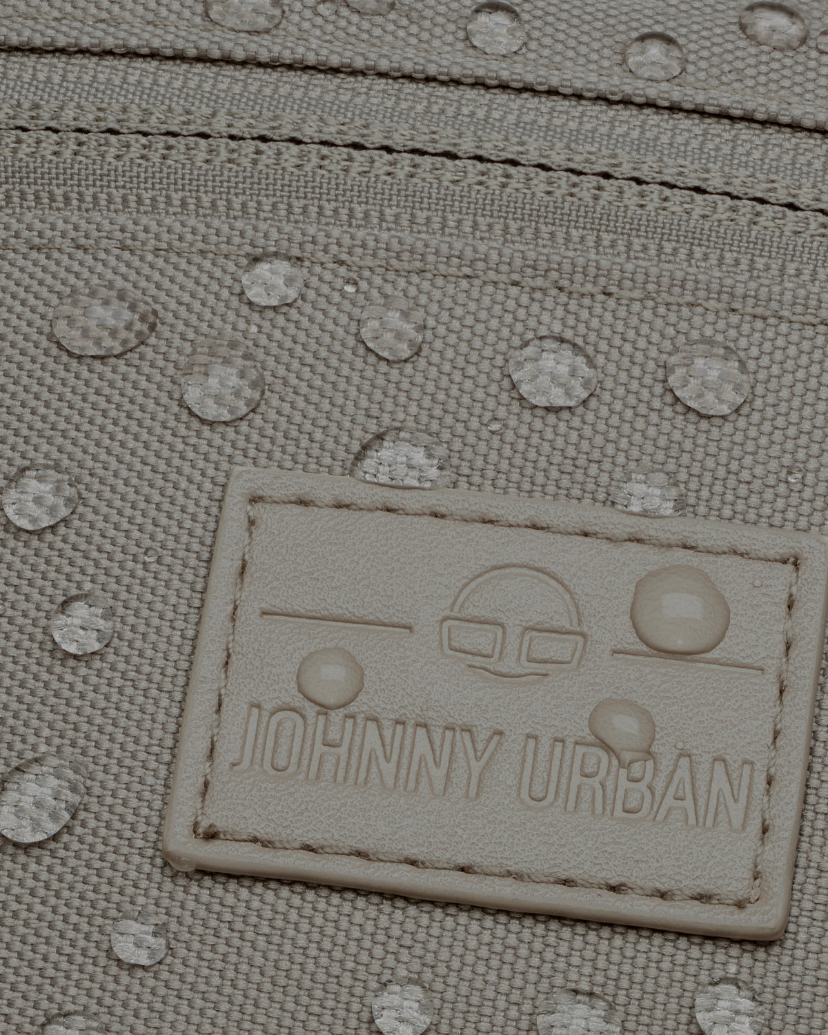 Wasserabweisende hellgraue Bauchtasche 'Ben' von Johnny Urban mit sichtbaren Wassertropfen und Markenetikett
