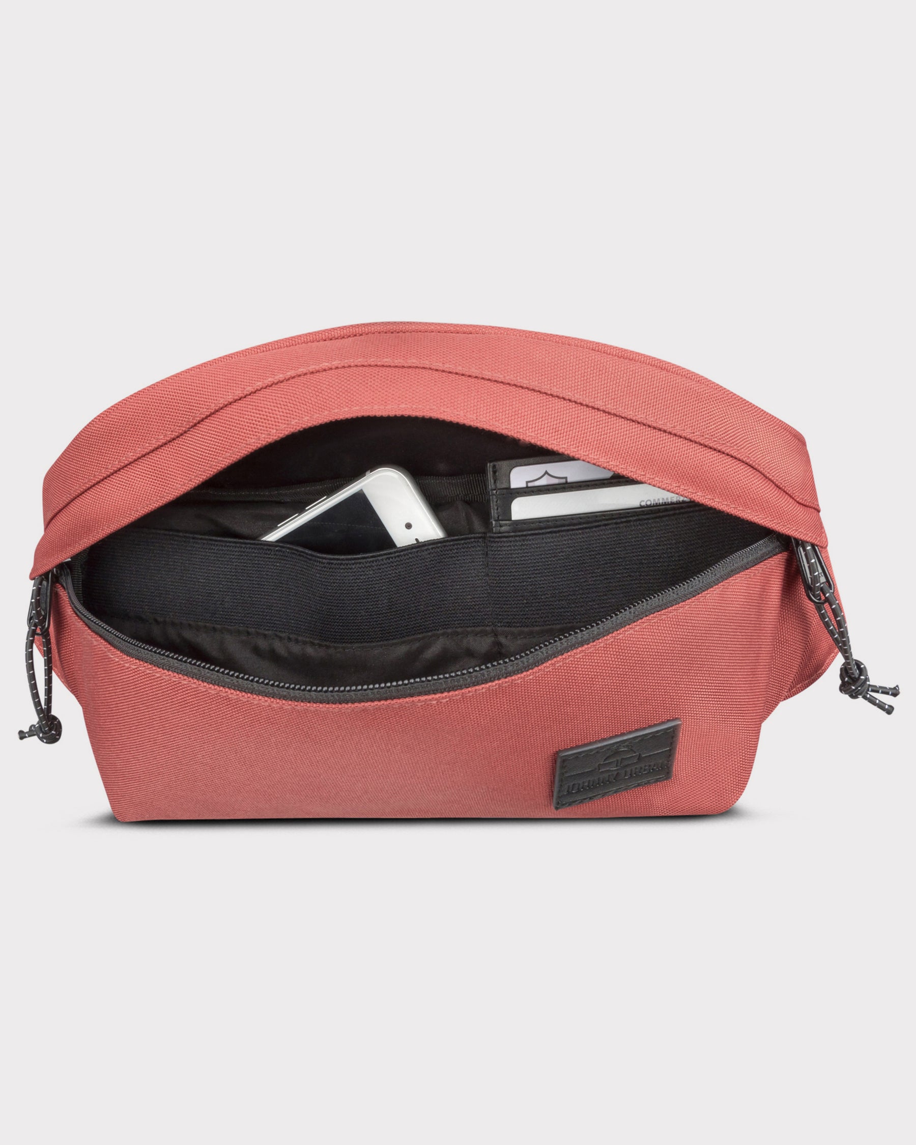 Große rote Bauchtasche 'Tom' mit geöffnetem Hauptfach, darin ein Smartphone und Kartenfächer