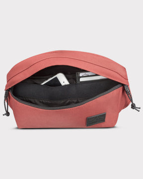 Große rote Bauchtasche 'Tom' mit geöffnetem Hauptfach, darin ein Smartphone und Kartenfächer