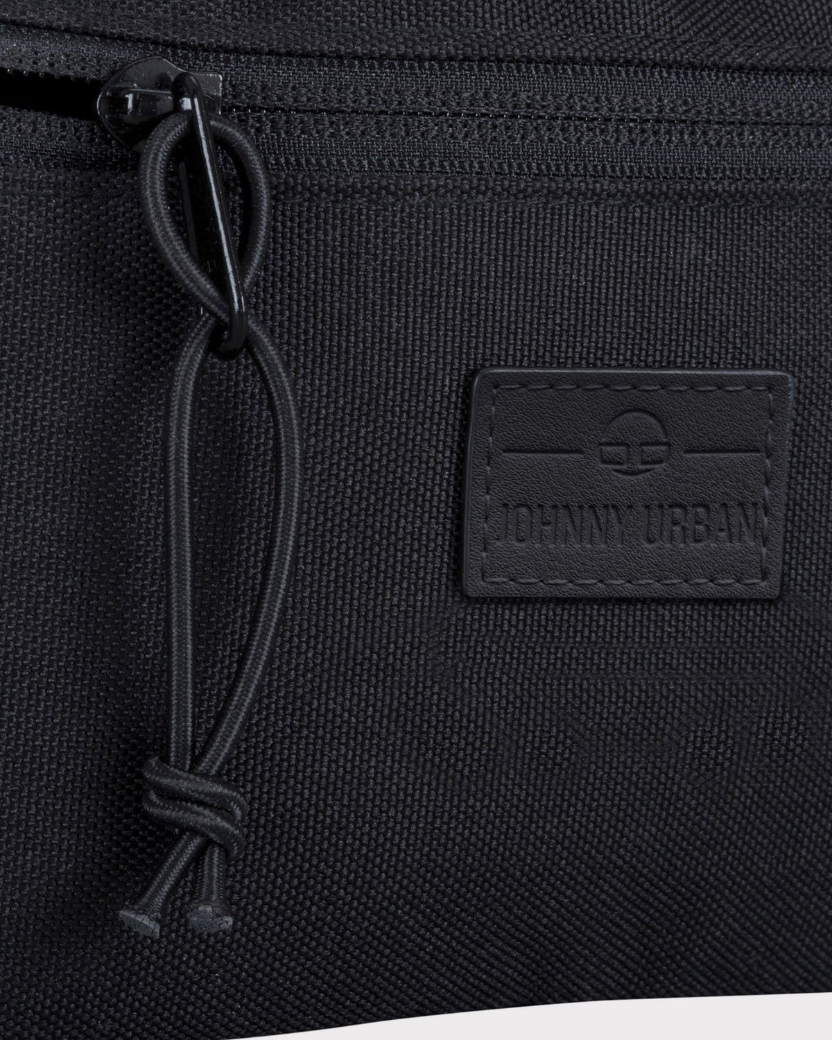 Nahaufnahme der schwarzen Bauchtasche 'Erik Small' von Johnny Urban mit Reißverschluss und Logo-Patch