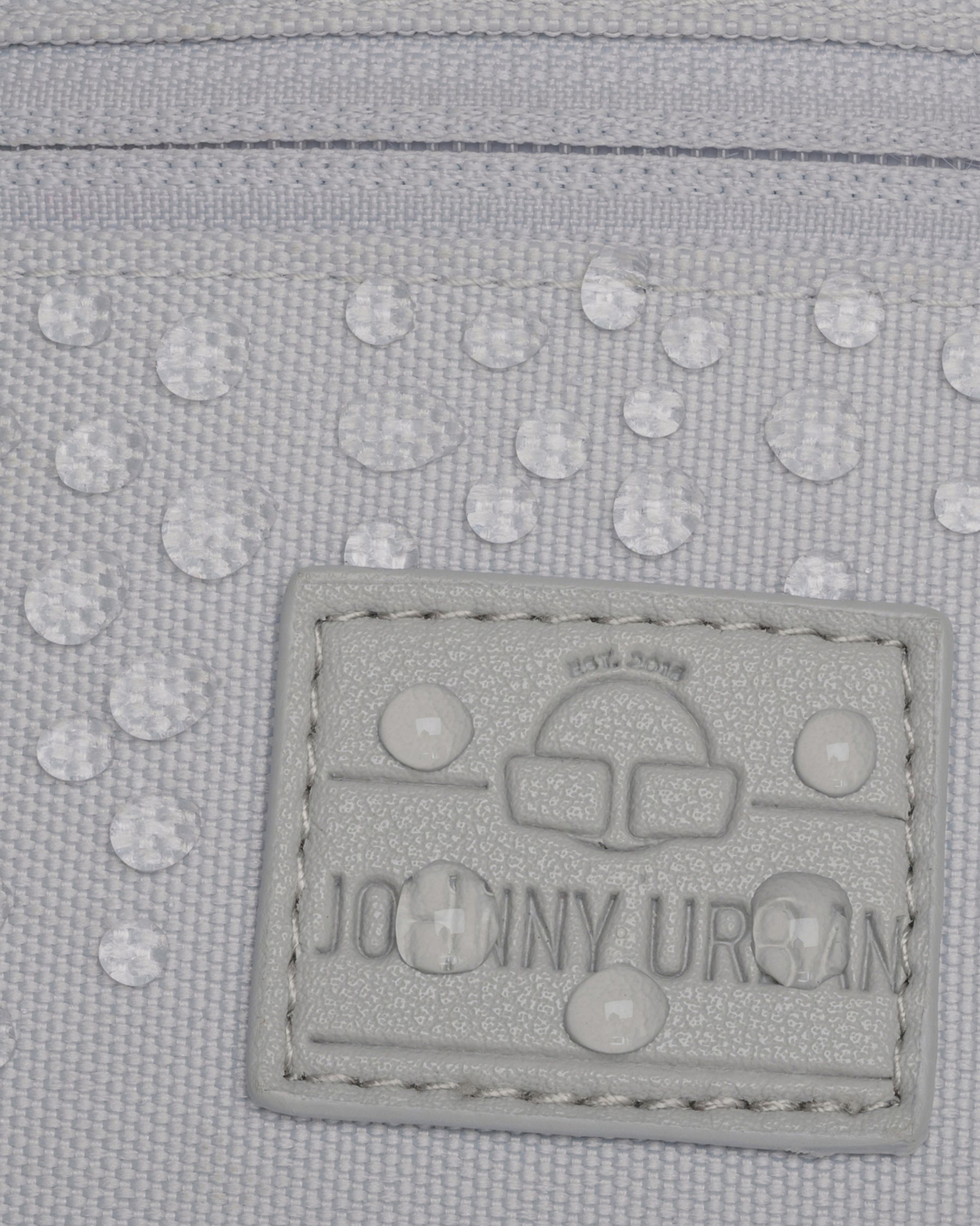 Nahaufnahme des wasserabweisenden Materials und des Logos der grauen Bauchtasche 'Erik Small' von Johnny Urban