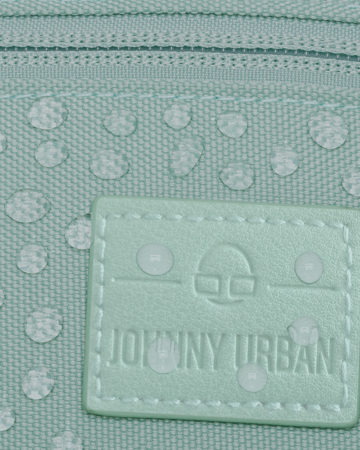 Mintgrüne, wasserabweisende Bauchtasche 'Erik Small' von Johnny Urban mit Logoetikett und Wassertropfen auf dem Material