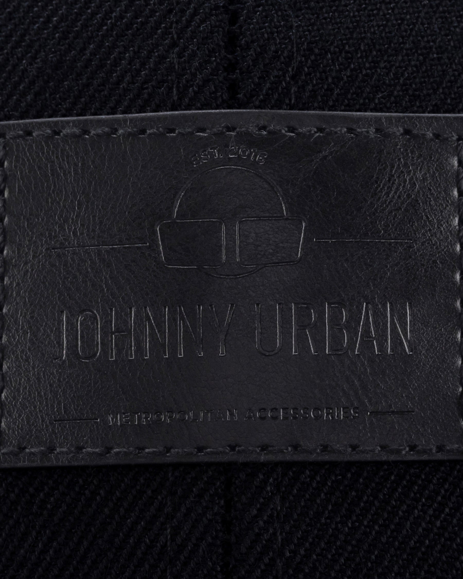Schwarzes Lederetikett mit eingeprägtem Logo und Text 'Johnny Urban', auf dunklem Stoff mit sichtbarer Naht