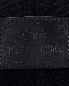 Schwarzes Lederetikett mit eingeprägtem Logo und Text 'Johnny Urban', auf dunklem Stoff mit sichtbarer Naht