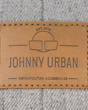 Nahtloses braunes Lederetikett mit Johnny Urban-Logo und Schriftzug auf grauer Textilstruktur
