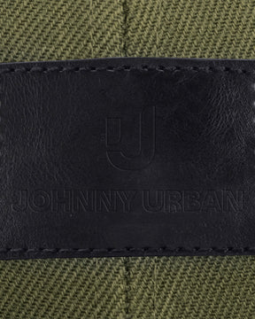 Schwarzes Lederlabel mit eingeprägtem Johnny Urban Logo und Text auf grünem Stoff