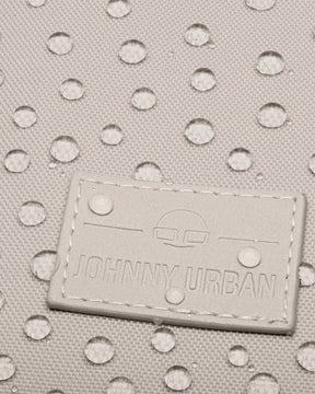 Nahe Nahaufnahme des wasserdichten Materials des Johnny Urban Rolltop Rucksacks "Robin Medium" mit aufgenähtem Logo