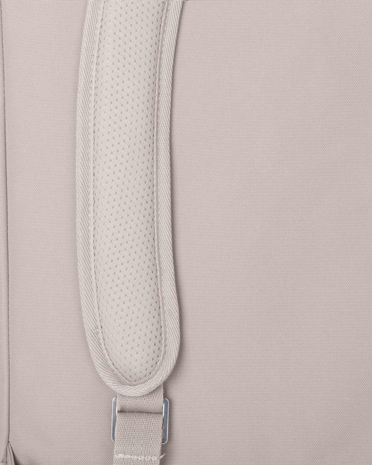 Nahaufnahme eines gepolsterten Trägerteils eines hellbeigen Rolltop Rucksacks Robin Medium