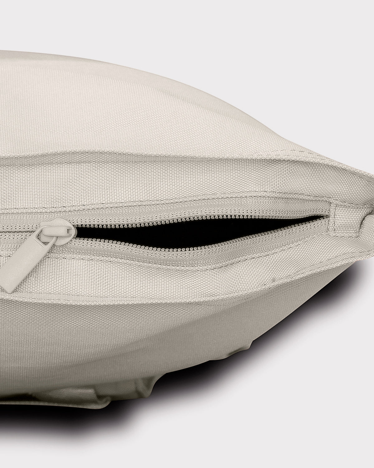 Seitliche Nahaufnahme der offenen Reißverschlusstasche des Rolltop Rucksack "Robin Medium" in hellem Stoff
