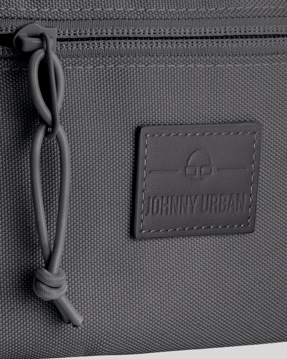 Gepäckdetail der Bauchtasche 'Erik Small' von Johnny Urban mit Reißverschluss und Logo-Patch.