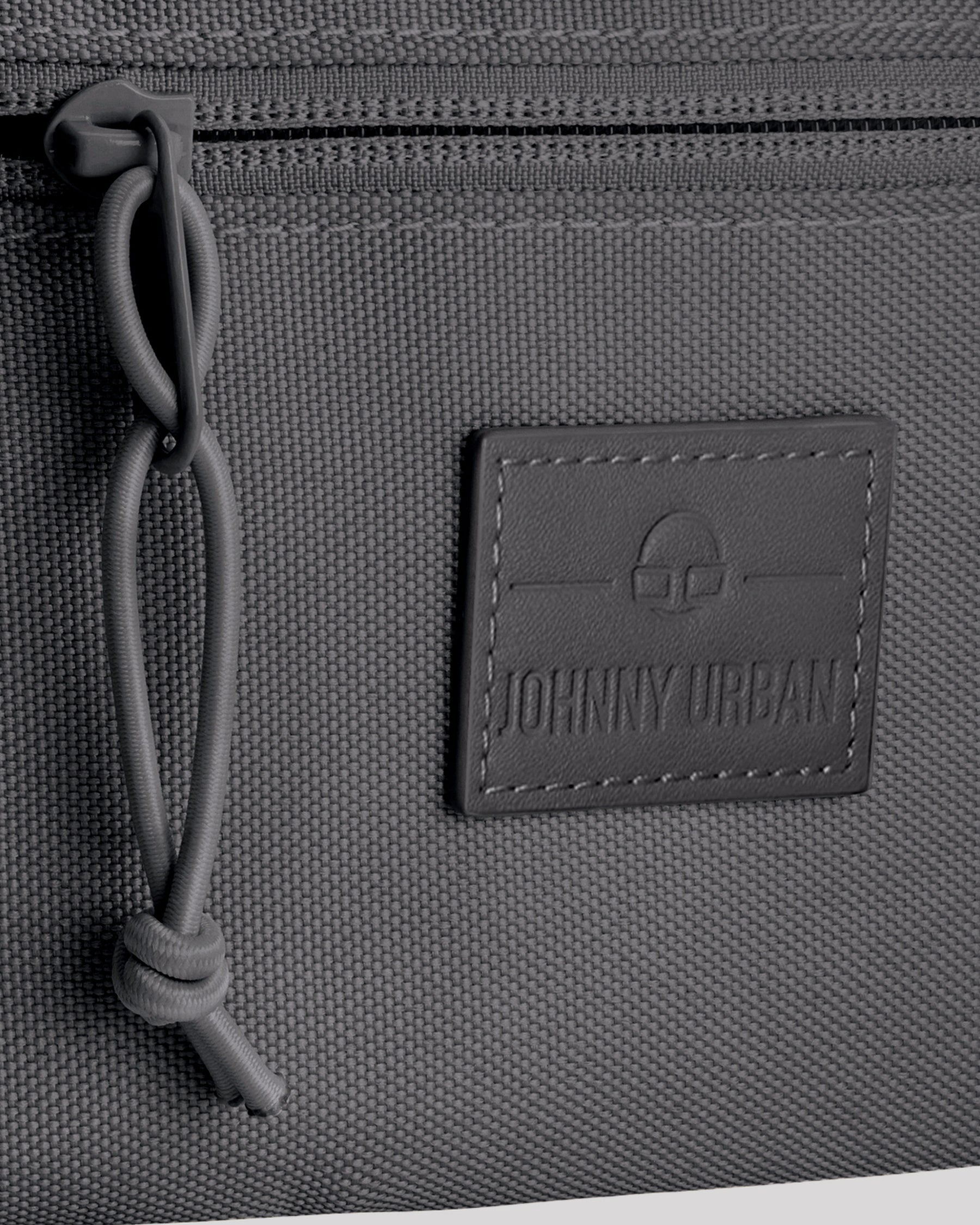Gepäckdetail der Bauchtasche 'Erik Small' von Johnny Urban mit Reißverschluss und Logo-Patch.
