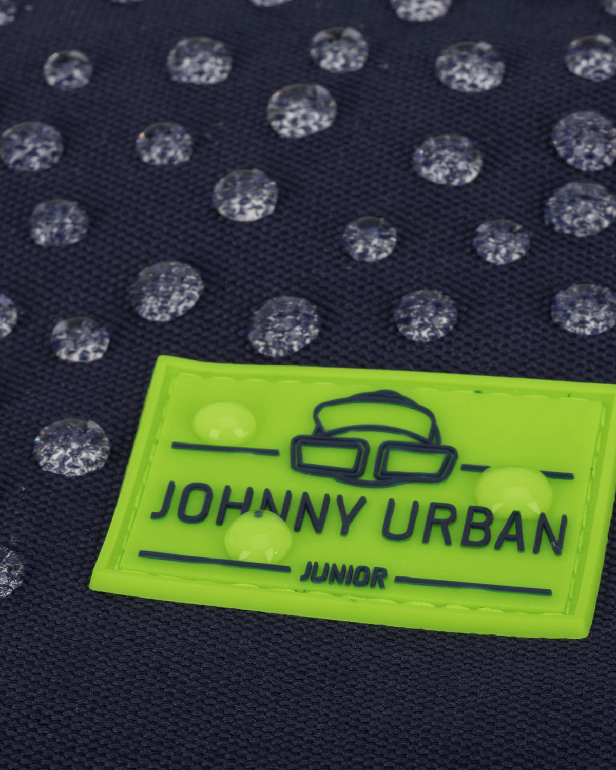 Wasserdichter dunkelblauer Kinderrucksack mit reflektierenden Punkten und grünem Johnny Urban Junior Logo