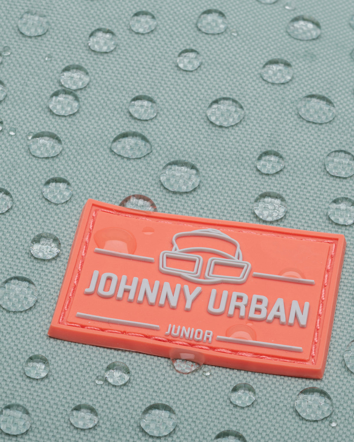 Nahaufnahme des wasserabweisenden Materials und Markenetiketts des Johnny Urban Kinderrucksacks 'Linus'