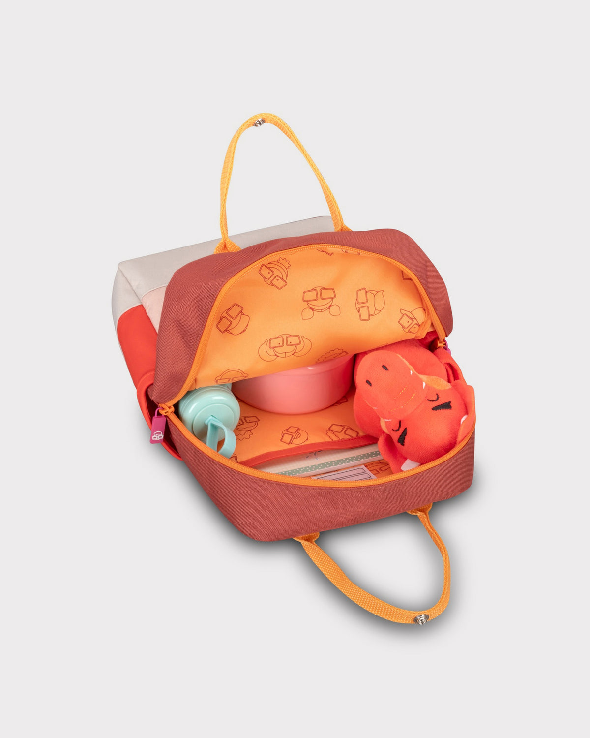 Kinderrucksack 'Linus' in Rot- und Beigetönen, geöffnet mit integriertem Innenfutter und Kinderspielzeug darin
