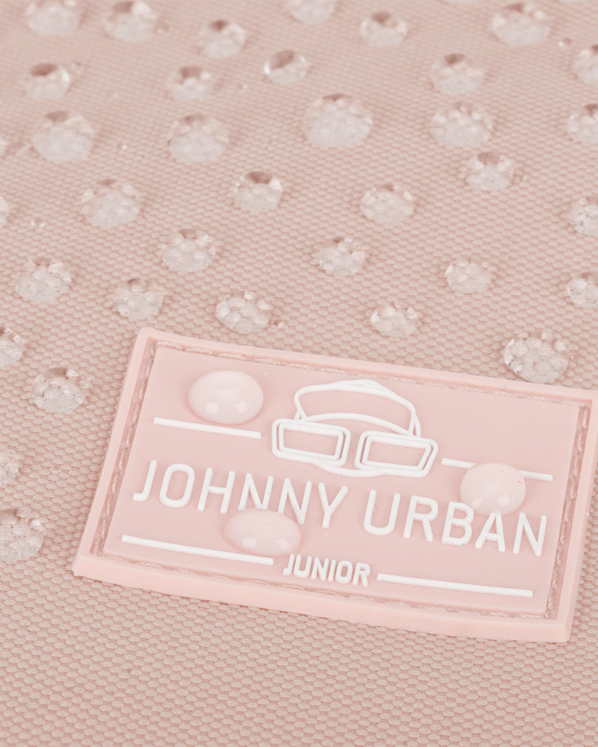 Nahaufnahme eines rosa Kinderrucksacks Liam von Johnny Urban Junior mit wasserabweisender Oberfläche und Wasserperlen