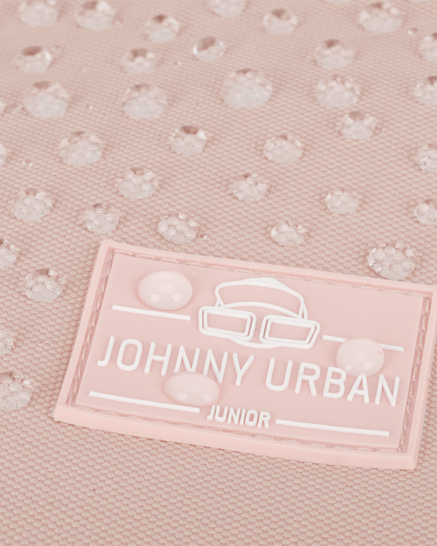 Nahaufnahme eines rosa Kinderrucksacks Liam von Johnny Urban Junior mit wasserabweisender Oberfläche und Wasserperlen