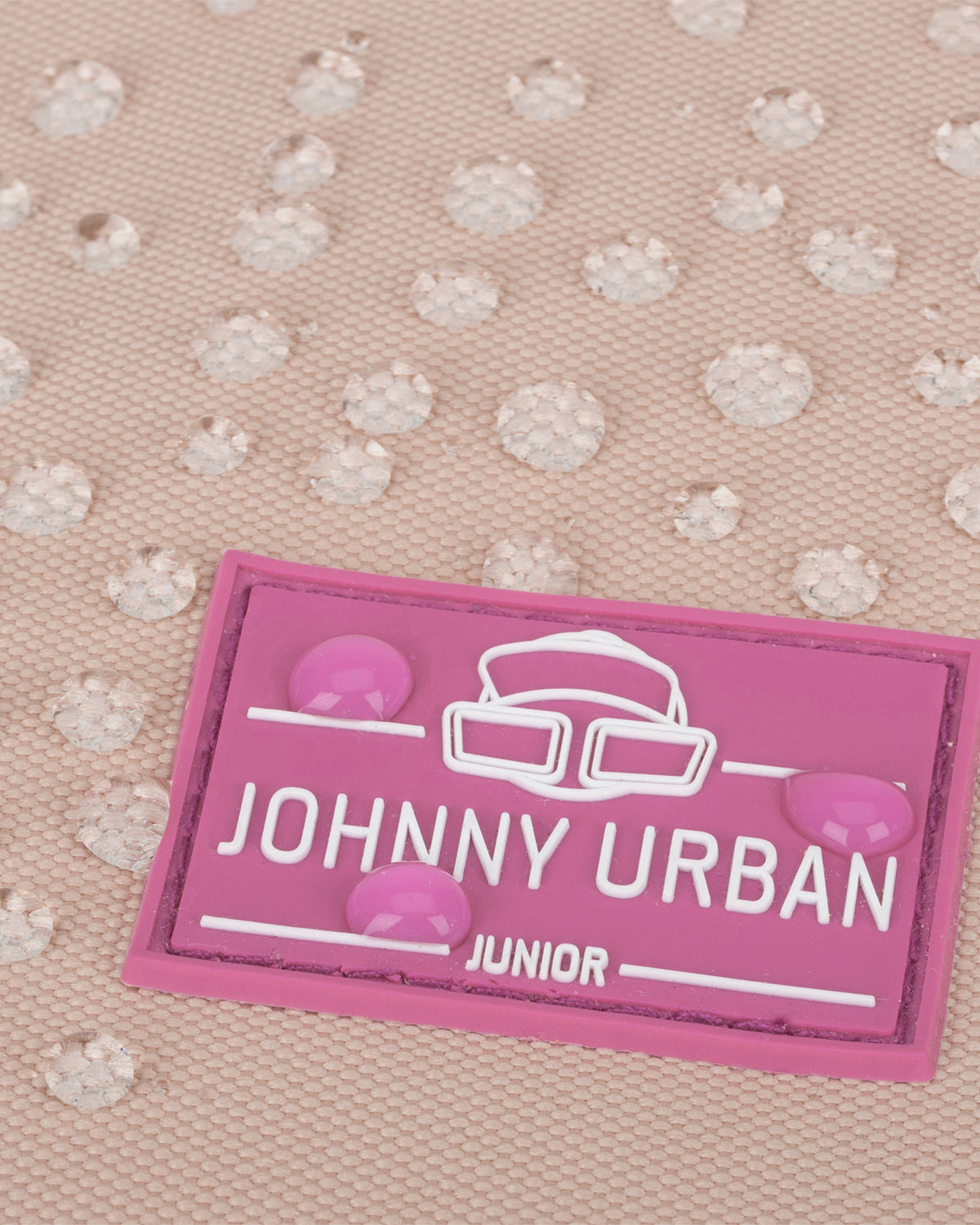 Nahaufnahme des wasserabweisenden Stoffs mit pinkfarbenem Johnny Urban Junior Logo auf dem Kinderrucksack 'Liam'