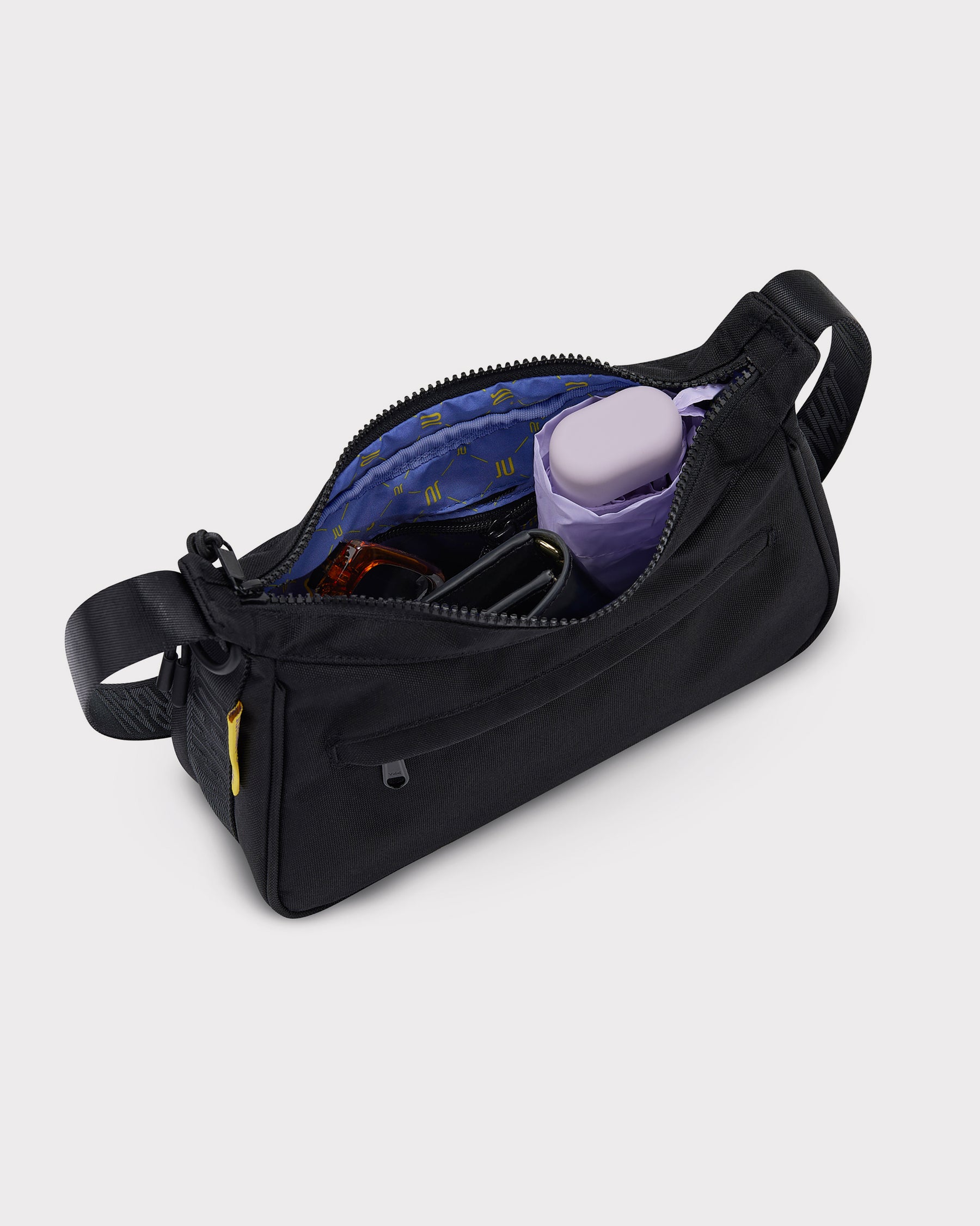 Schwarze Handtasche 'Maddy' von Johnny Urban mit Reißverschluss geöffnet, innen blaue Tasche mit gelbem Muster, enthält lila Etui, Brille und Geldbörse