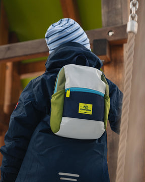 Kind trägt Kinderrucksack 'Leo' von Johnny Urban in Blau, Olivgrün und Grau auf dem Rücken