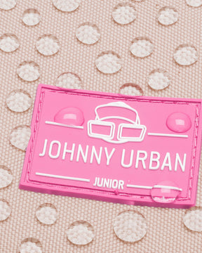 Nahaufnahme des rosa Johnny Urban Junior Logos auf wasserabweisendem Stoff mit Wassertropfen