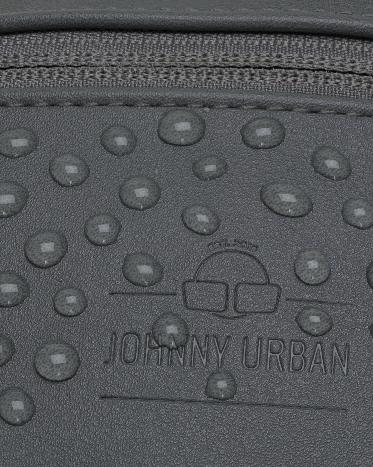 Nahaufnahme der wasserabweisenden grauen Kunstleder-Bauchtasche 'Toni' von Johnny Urban mit sichtbaren Wassertropfen