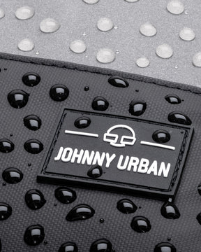 Nahaufnahme des wasserdichten Rucksacks 'Mika' mit Johnny Urban Logo und Wassertropfen auf der Oberfläche