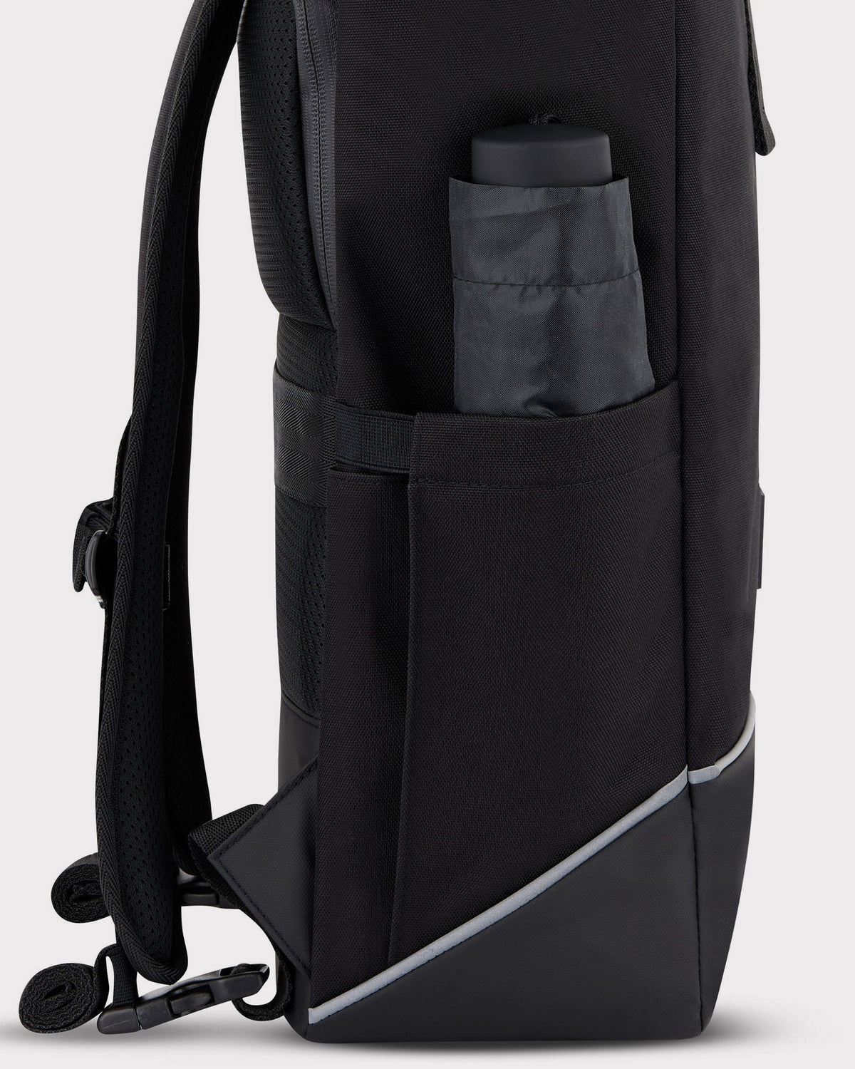 Seitlicher Blick auf den schwarzen Rolltop Rucksack 'Robin Medium' von Johnny Urban mit Seitentasche und integriertem Schutz für Fahrradgepäckträger