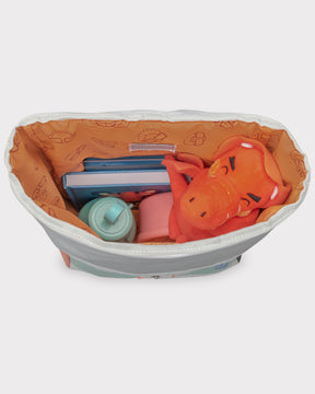 Offener Rolltop Kinderrucksack Aaron mit orangefarbenem Innenfutter, gefüllt mit blauen Büchern, rotem Drachenplüsch, Trinkflasche und Lunchbox