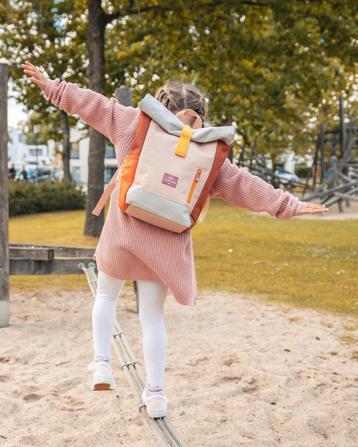 Mädchen balanciert auf Seil im Park mit rosa Rolltop Kinderrucksack 'Aaron' von Johnny Urban