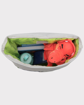 Blick in den Rolltop Kinderrucksack 'Aaron' mit grünem Innenfutter, rotem Stofftier Drachen, Wasserkunststoffflasche und Büchern