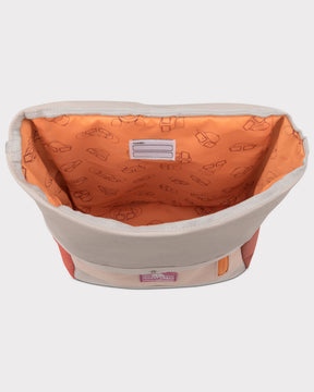 Innenansicht des rosa-bunten Rolltop Kinderrucksacks „Aaron“ mit orangefarbenem Innenfutter, gefüllt mit roten Plüschtier, zwei Büchern und Trinkflasche