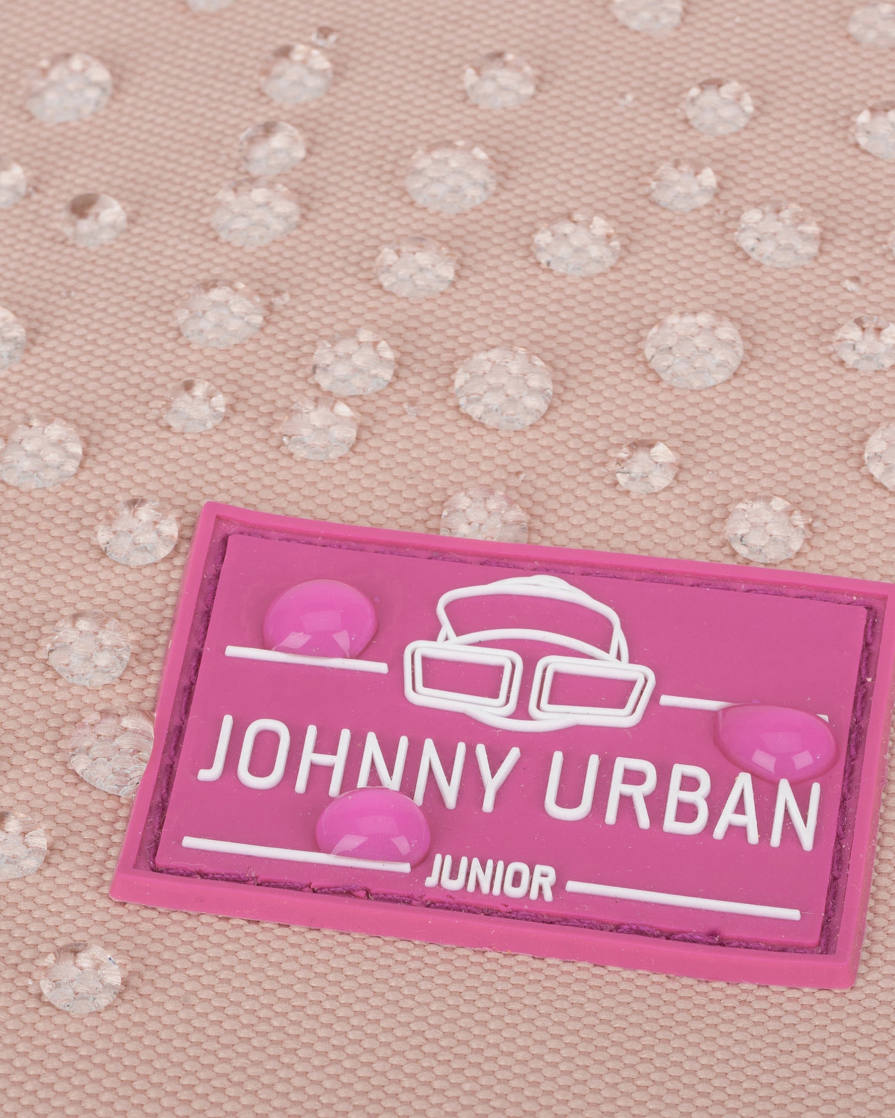 Nahaufnahme eines rosa wasserdichten Rolltop-Kinderrucksacks 'Aaron' mit 'Johnny Urban Junior'-Logo