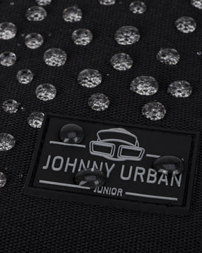 Nahaufnahme eines schwarzen wasserdichten Rolltop Kinderrucksacks 'Aaron' mit Johnny Urban Junior Logo und Wasserperlen