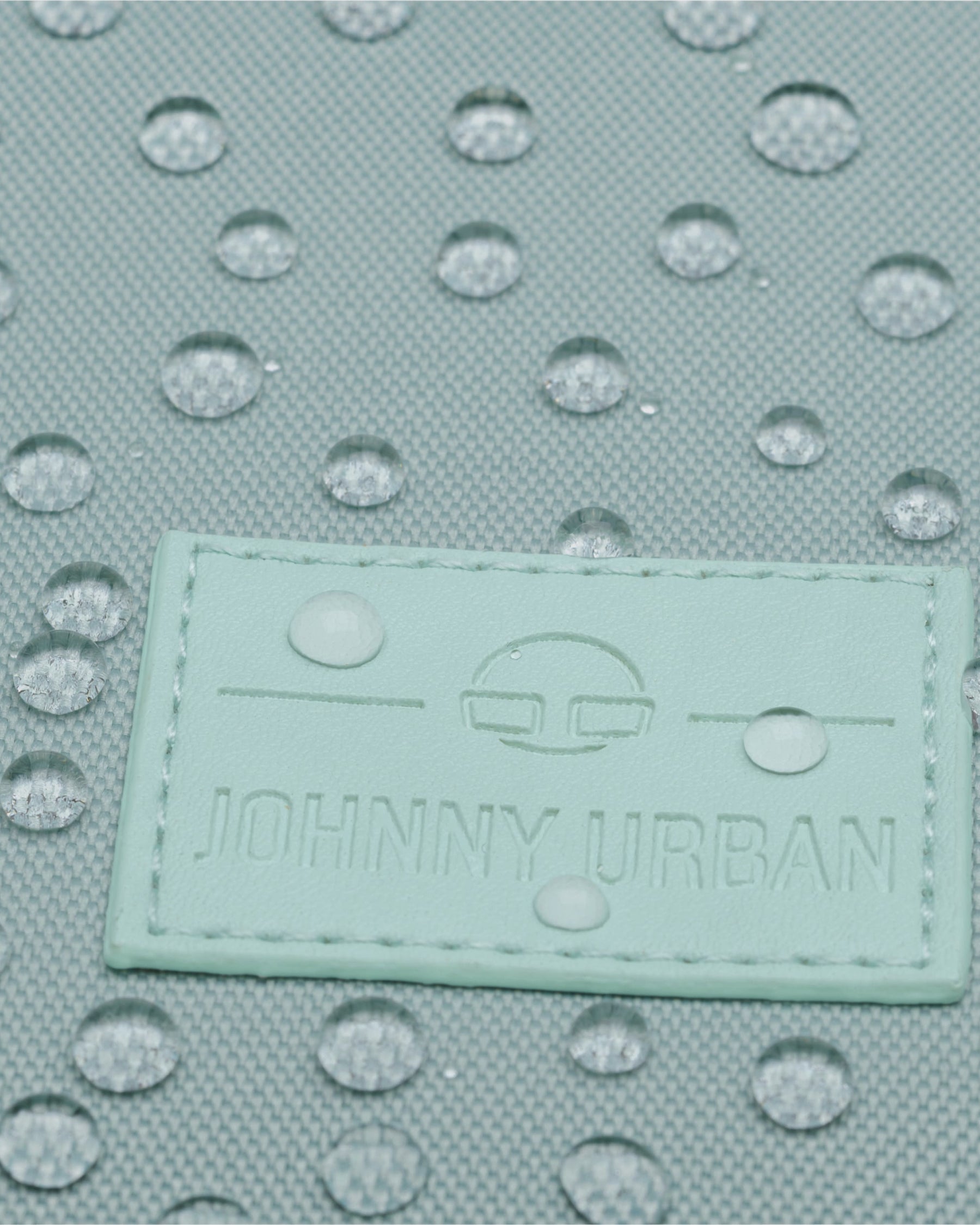Mintfarbener Stoff des Rolltop Rucksacks 'Robin Small' mit wasserabweisender Beschichtung und Johnny Urban Logo