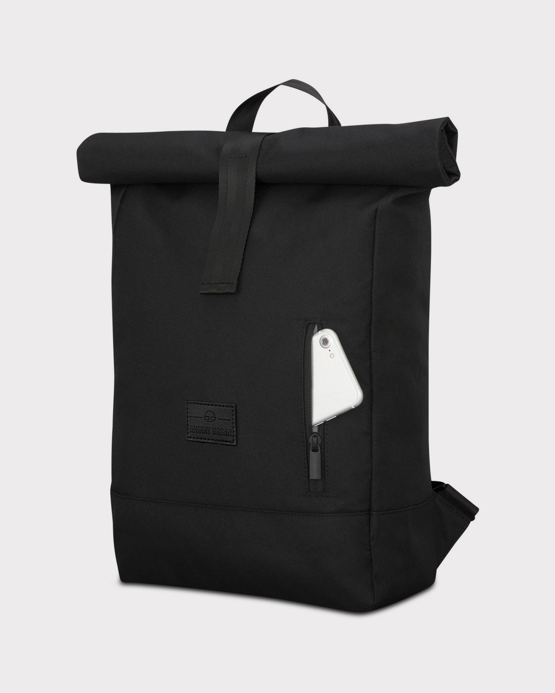 Schwarzer Rolltop Rucksack 'Robin Medium' von Johnny Urban mit Außentasche, darin ein Smartphone