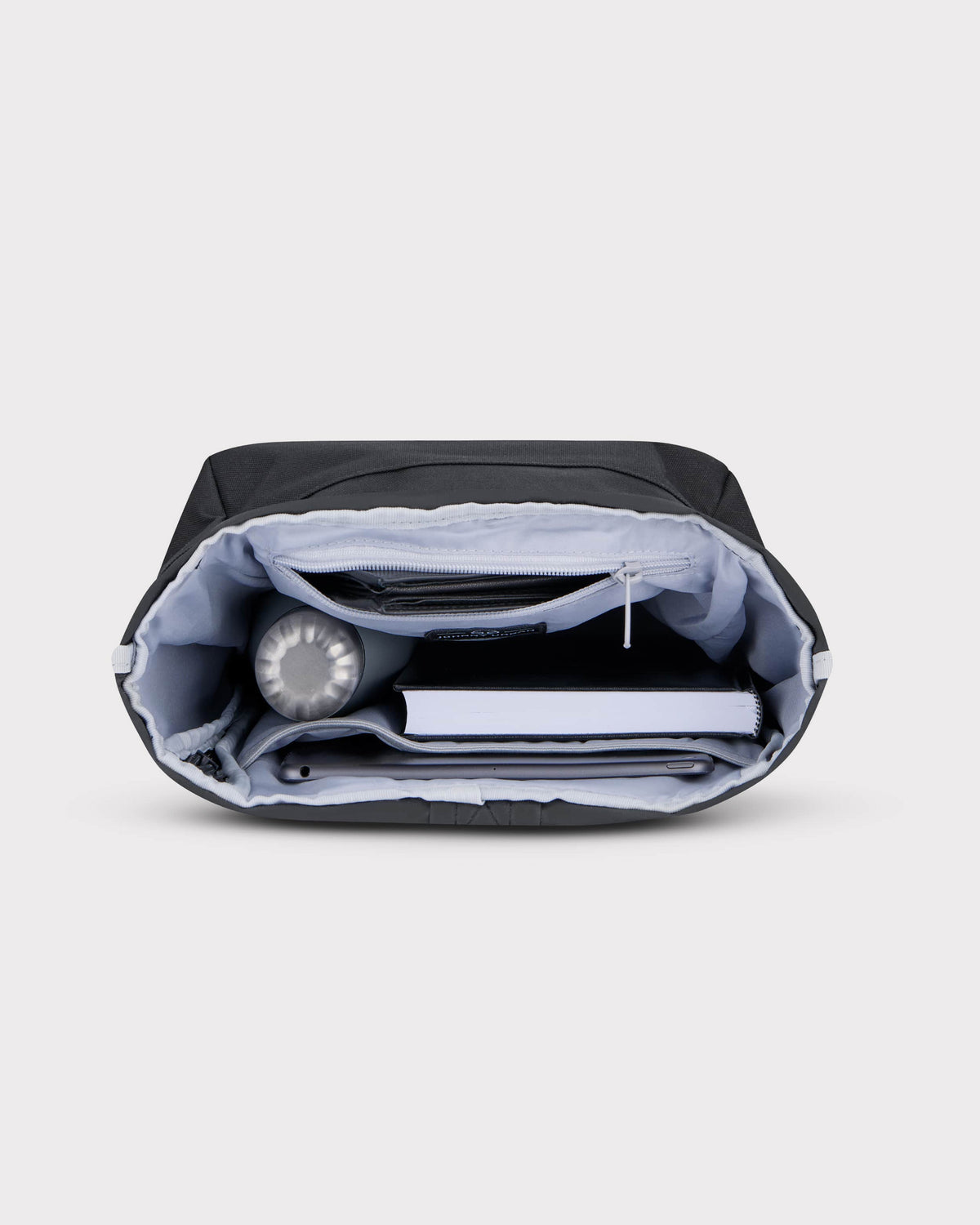 Rolltop Rucksack Robin Small in Schwarz mit organisiertem Innenraum, gefüllt mit Wasserflasche, Buch und Tablet