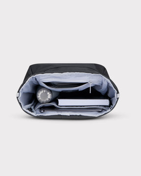 Rolltop Rucksack Robin Small in Schwarz mit organisiertem Innenraum, gefüllt mit Wasserflasche, Buch und Tablet