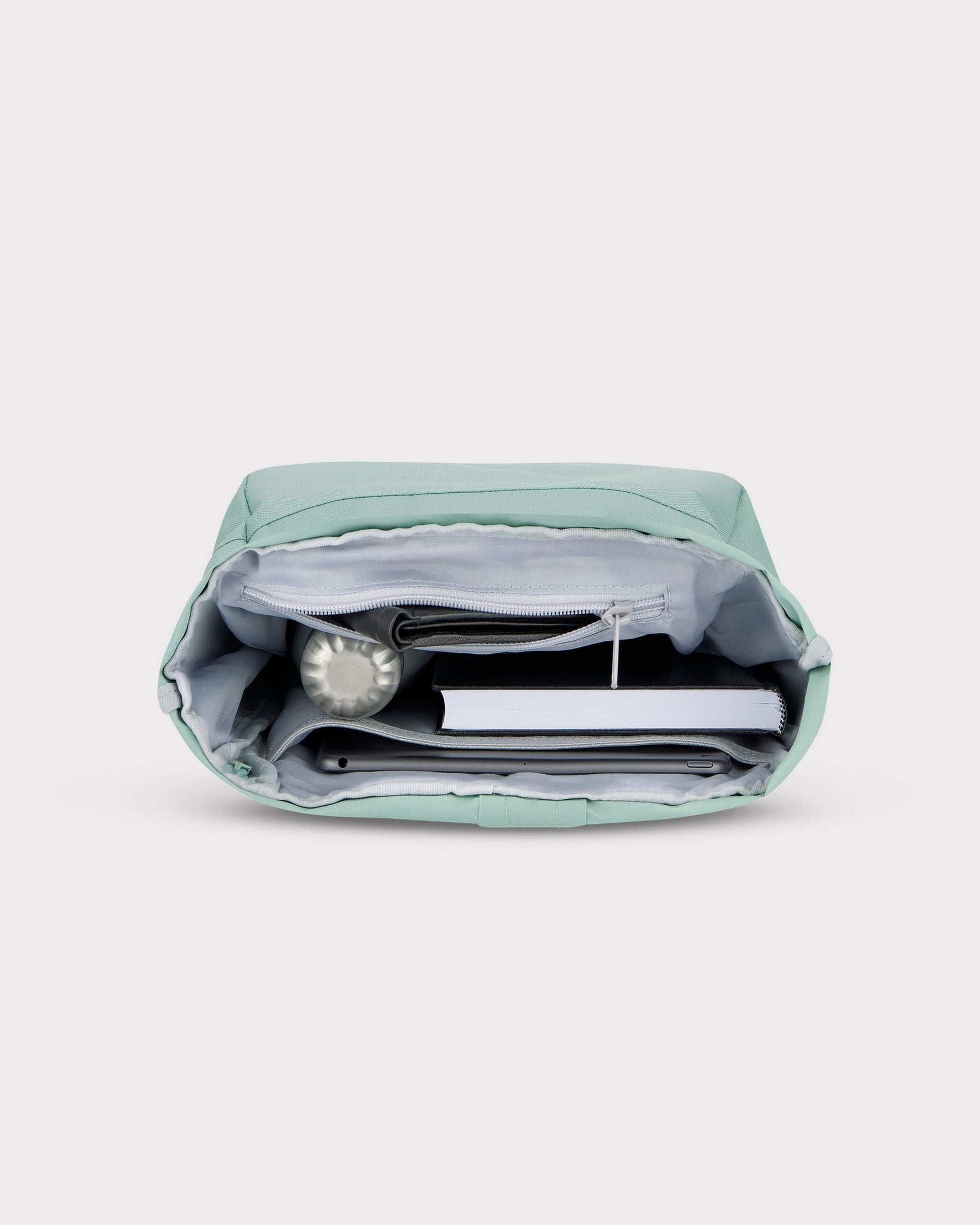 Offener mintgrüner Rolltop Rucksack Robin Small mit Fächern, gefüllt mit Wasserflasche, Notizbuch, Tablet und Geldbörse