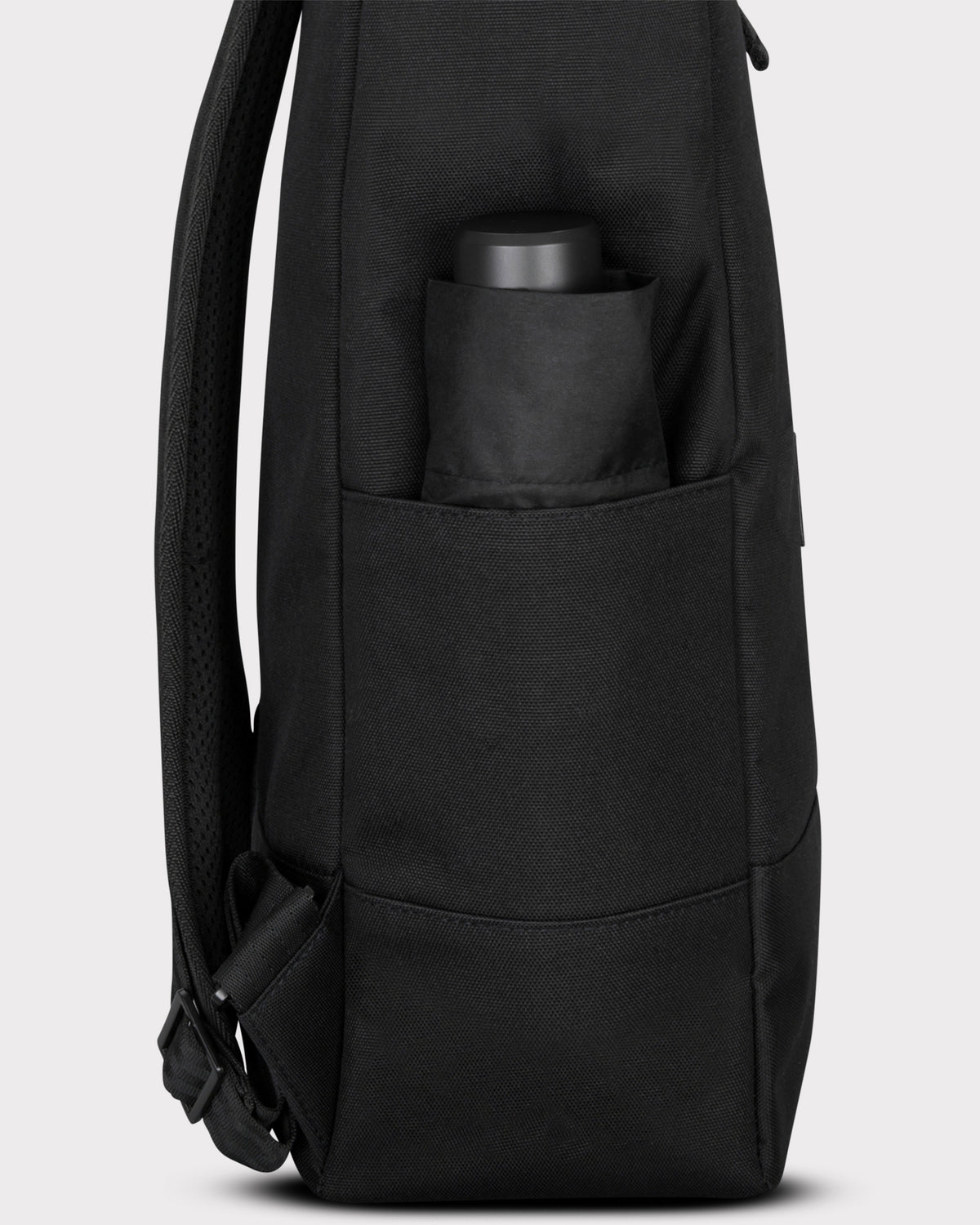 Seitenansicht des schwarzen Rolltop Rucksacks 'Robin Large' mit Flaschenfach und Wasserflasche