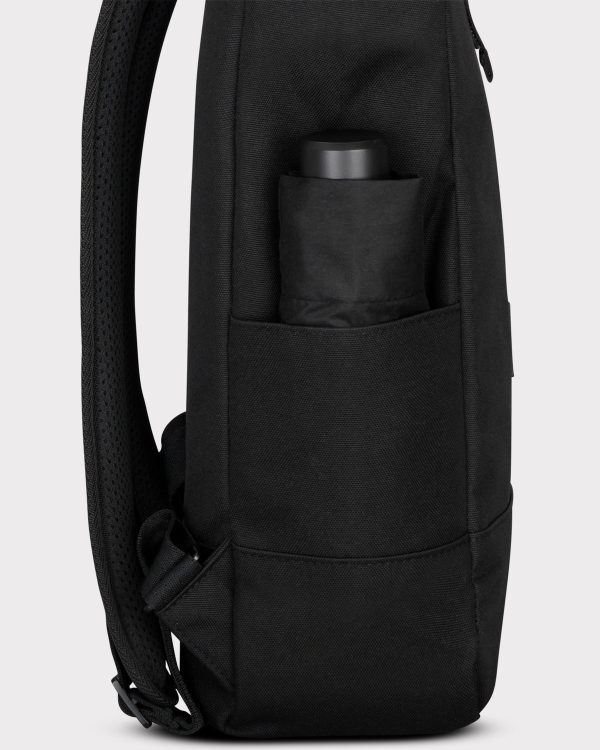 Seitenansicht des schwarzen Rolltop-Rucksacks 'Robin Medium' mit Regenschirm in der Tasche