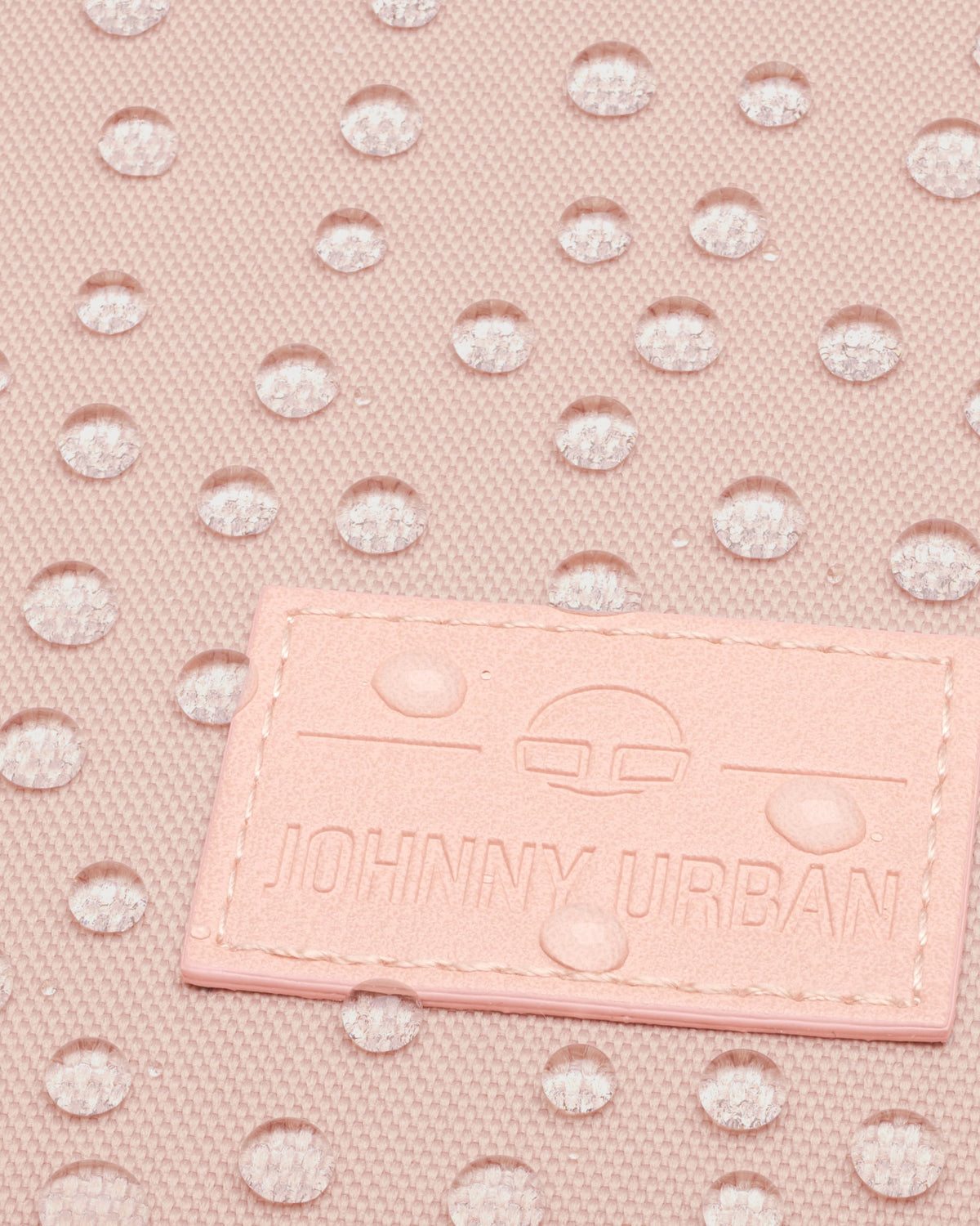 Wasserabweisender rosa Stoff mit Johnny Urban Markenlogo auf einem Rolltop Rucksack