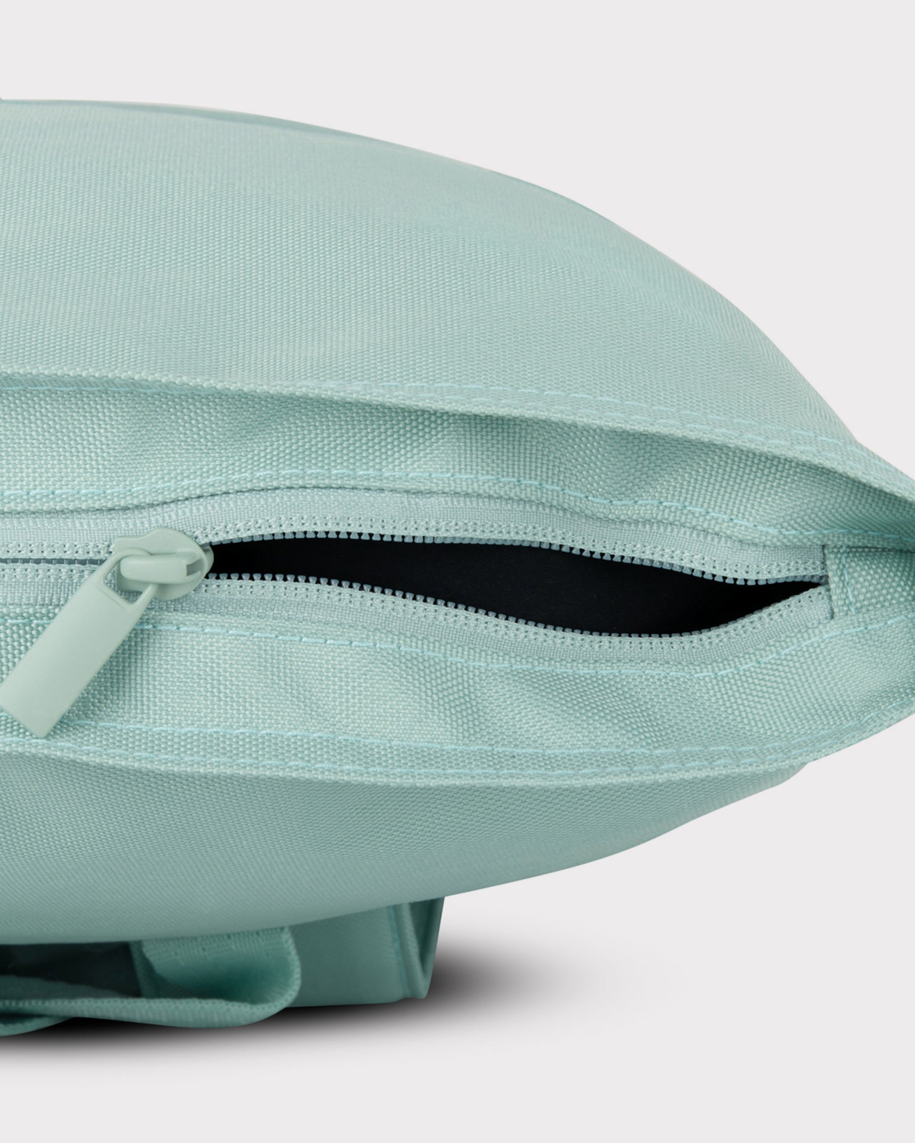 Mintgrüner Rolltop Rucksack 'Robin Medium' mit geöffneter seitlicher Reißverschlusstasche